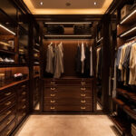 An Elegant Walk-In Closet Featuring Custom Cabinets, Neatly Organized Clothes, And Subtle, Warm Lighting.